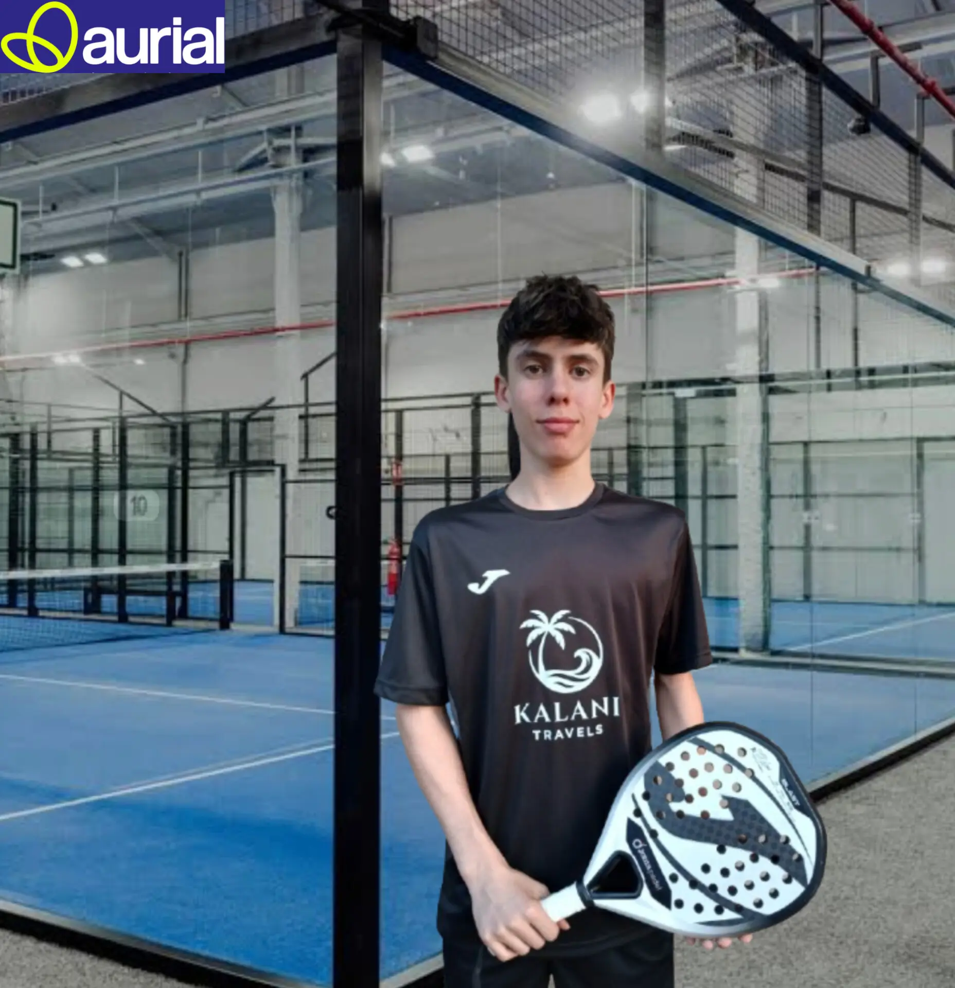 Aleix Fortes con la camiseta de Kalani Travels y su pala, en una pista de pádel cubierta
