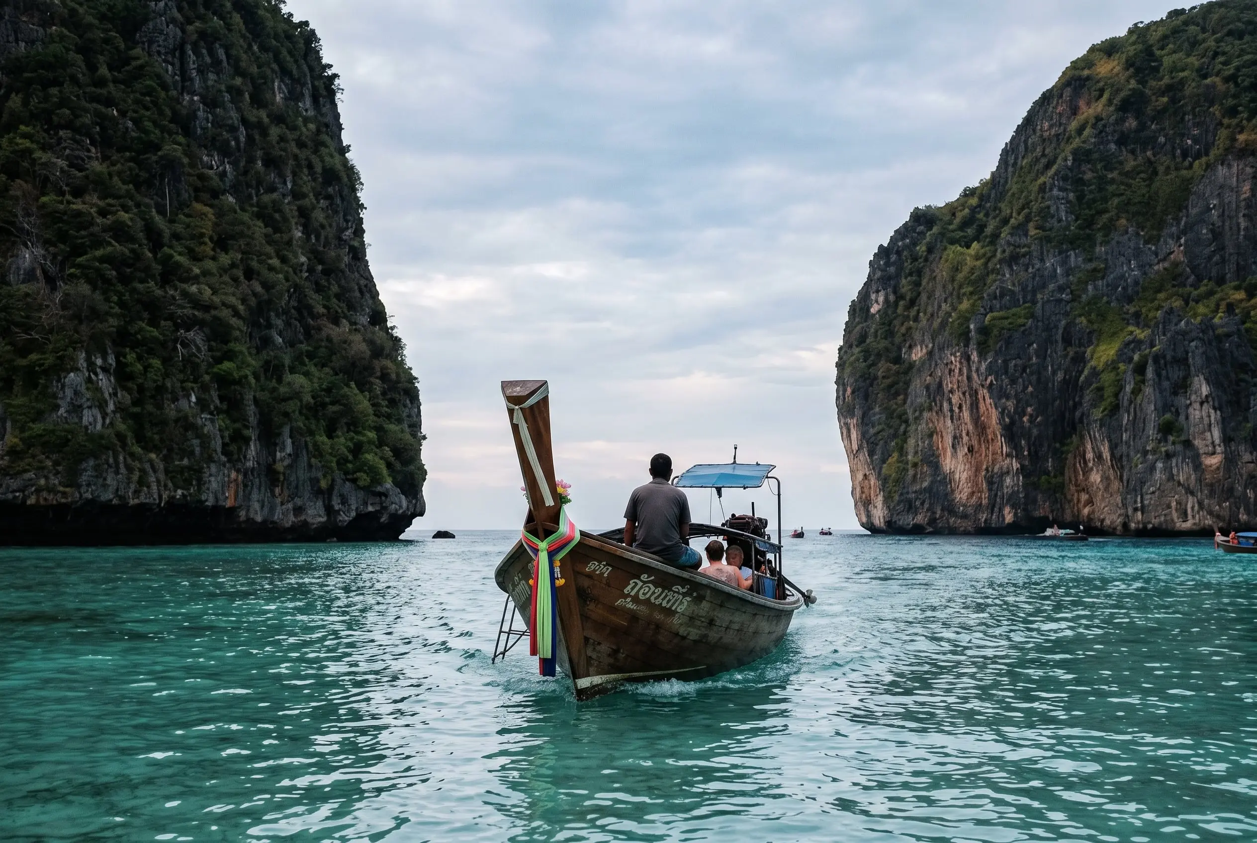 Barca de cola larga en aguas turquesas entre los acantilados de piedra caliza de las islas Phi Phi